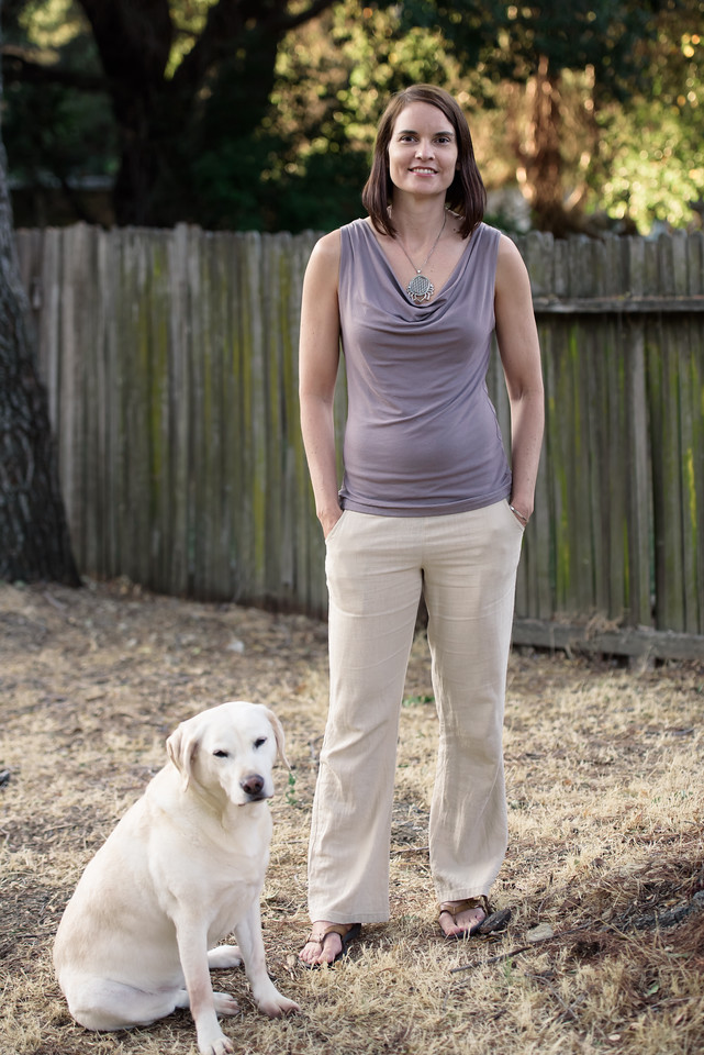 photo of Rachel Hope standing next to a white dog